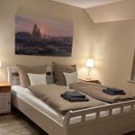 Schlafzimmer mit Doppelbett, zwei Nachttischen und Wandbild.