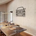 Esszimmer mit Holzwand und Tisch mit Stühlen. Wanddekoration zeigt Fahrzeug.