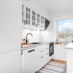 Küche mit weißen Schränken, Fenster und Kücheninsel.