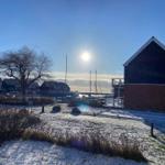 Schneebedeckter Garten mit Blick auf Hafen und Segelyachten.