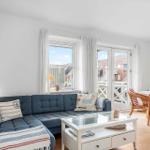 Ein Wohn- und Essbereich mit Sofa, Tisch und Stühlen. Durchgänge zu einer Terrasse.