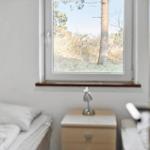 Schlafzimmer mit Fensterblick auf Baum und Gras