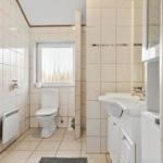 Badezimmer mit Toilette, Waschbecken und Fenster.