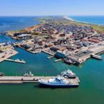 Hafenstadt mit Booten und Strand im Hintergrund