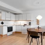 Küche mit Essbereich, Holzboden und weißen Schränken.