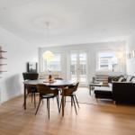 Wohn- und Essbereich mit Esstisch, Sofa und Küchenzeile.