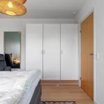 Schlafzimmer mit Bett, Kleiderschrank und Wandspiegel.