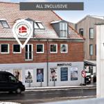 Ferienhaus mit rotem Dach und weißen Fenstern in Hvide Sande.