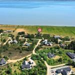 Luftbild von Ferienhäusern am Ufer eines Sees mit Wald und Wegen.