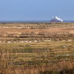 Ferries fährt über das Meer, umgeben von trockenem Grasland.