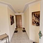 Flur mit Spiegel, Kunstwerken und Tür zum Aufzug.