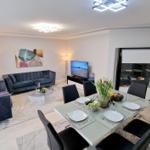 Wohn- und Essbereich mit Sofa, Esstisch und TV.