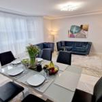 Essbereich mit Tisch und Stühlen. Wohnbereich mit Sofa und Fernseher.