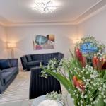 Wohnzimmer mit zwei Sofas, Wandbild und Blumenstrauß im Vordergrund.