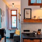 Küche mit Induktionskochfeld und Holzschrank. Nebenraum mit Fenster und gemusterter Fliesenboden.