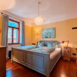 Schlafzimmer mit Bett, Fenster und Deckenleuchte.