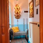 Eingangsbereich mit Bänkchen, Wandlampe und Mosaikboden.