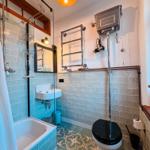 Bad mit Badewanne, Toilette und Waschbecken. Wandfliesen und Bodenfliesen.