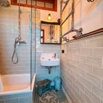 Badezimmer mit Badewanne, Dusche, Waschbecken und Spiegel.