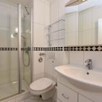 Badezimmer mit Dusche, Toilette und Waschbecken.