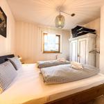 Schlafzimmer mit Doppelbett, Fenster, Kleiderschrank und Decke.