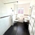 Badezimmer mit Dusche, Toilette, Waschbecken und Heizkörper.