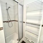 Dusche mit Duschbrause und Heizkörper an der Wand.