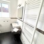 Badezimmer mit Waschbecken, Spiegel und Heizkörper an der Wand.