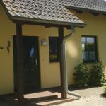 Haus mit gelber Fassade, Eingangstür und Dachüberstand. Hausnummer 5a sichtbar.