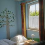 Ein Zimmer mit blauen Wänden, einem Bett und einem Fenster mit Vorhängen.