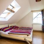 Schlafzimmer mit Dachschräge, Dachfenster, Bett und Kleiderschrank.