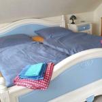 Doppelbett mit blauer Bettwäsche und gefalteten Handtüchern