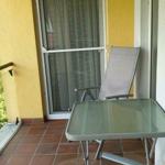 Terrasse mit Tisch, Stuhl und Blick auf grüne Vegetation.
