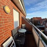 Terrasse mit Tisch, Stühlen und Blick auf die Nachbarschaft.