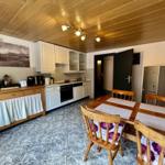Küche mit Essbereich, Holztisch, Stühle und Kühlschrank