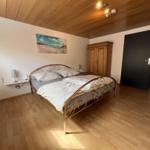 Schlafzimmer mit Doppelbett, Holzboden und Wandbild. Holzdecke und Kleiderschrank.
