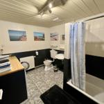Badezimmer mit Badewanne, Dusche, Toilette und Waschbecken.