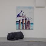 Ein Bild mit Möwen auf Pfählen hängt an der Wand. Ein Handtuch und ein Duftdiffusor stehen auf einer Bank.