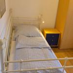 Ein Schlafzimmer mit einem Bett, Nachttisch und Kleiderschrank.