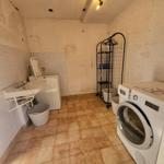 Waschraum mit Waschmaschine, Trockner und Waschbecken.