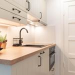 Küche mit Holzoberfläche, Edelstahlspüle und integriertem Backofen.