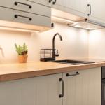 Küche mit Holzoberfläche, Edelstahlspüle und integriertem Ofen.