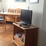 Dining area with wooden table, chairs, and TV on a sideboard.