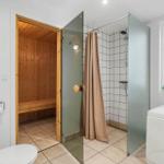 Bath with shower, bathtub, and sauna. Window with plant.