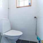Toilette mit Duschwand und Fenster im Badezimmer