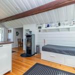 Schlafbereich mit Bett, Kamin und Küchenzeile unter Dachschrägen.