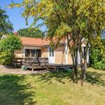 Ein gelbes Haus mit Terrasse und umliegenden Bäumen im Garten.