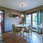 Esszimmer mit runden Tisch, Stühlen und Fensterblick auf Balkon
