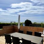 Terrasse mit Tisch, Stühlen und Blick aufs Meer