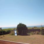 Hinterhof mit Rutsche und Schaukel, Blick auf das Meer.
